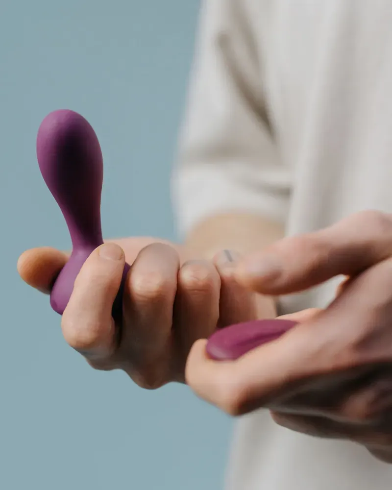 Hand holding a plum silicone vibrator