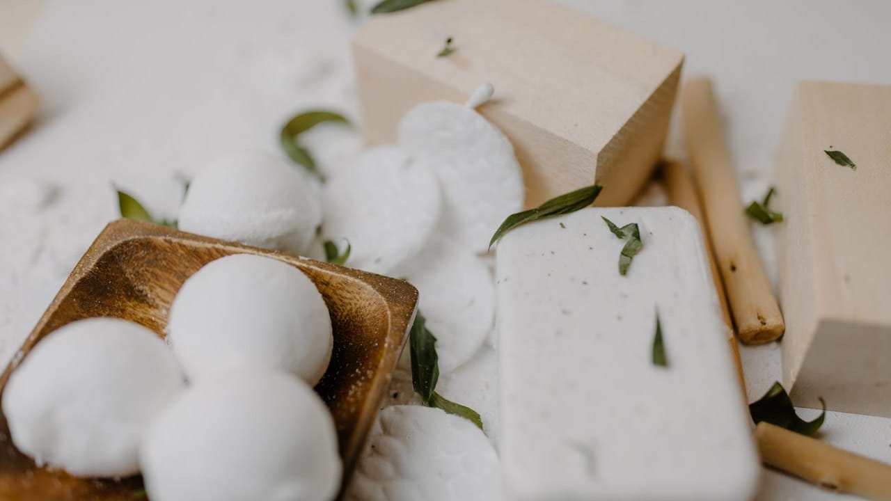 White bath bombs and handmade soap on a wooden tray