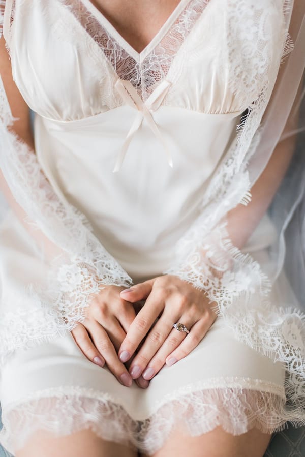 Ivory lace bridal chemise and engagement ring detail, soft editorial light