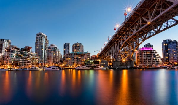 City waterfront at night with gold bridge lights