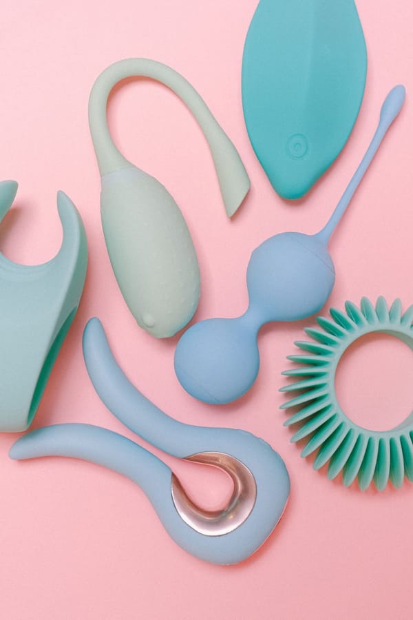 Assortment of pastel silicone toys laid out on a pink background